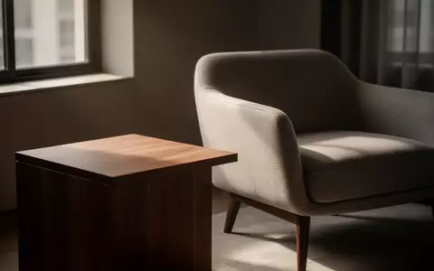 Ein minimalistisches, modern eingerichtetes Wohnzimmer mit einem leeren Beistelltisch und einem Sessel bei Tageslicht. - Foto: über boerse-global.de