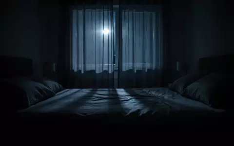 Ein abgedunkeltes Schlafzimmer bei Nacht, das nur von schwachem Mondlicht durch Vorhänge beleuchtet wird. - Foto: über boerse-global.de