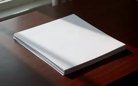 Ein Stapel leerer, weiĂer PapierblĂ€tter auf einem dunklen Holztisch, die eine AtmosphĂ€re von Datensicherheit und Vertraulichkeit vermitteln. - Foto: ĂŒber boerse-global.de
