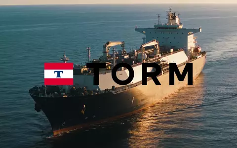 Ein großes Frachtschiff auf ruhigem Ozean bei Sonnenuntergang als Symbol für die maritime Logistikbranche. - Foto: über boerse-global.de