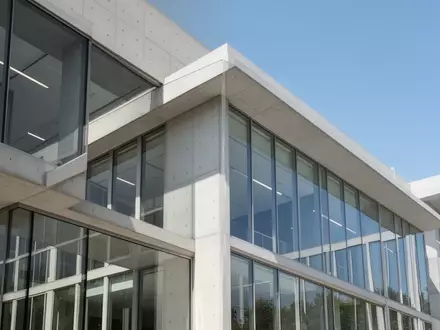 Moderne architektonische Fassade eines Bürogebäudes bei Tageslicht als Symbol für Transparenz und Verwaltung. - Foto: über boerse-global.de