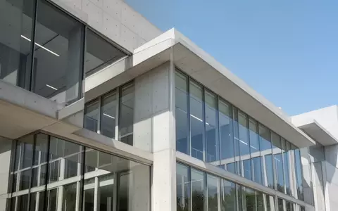 Moderne architektonische Fassade eines Bürogebäudes bei Tageslicht als Symbol für Transparenz und Verwaltung. - Foto: über boerse-global.de