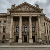 Ein neoklassizistisches Gerichtsgebäude mit massiven Säulen unter bewölktem Himmel. - Foto: über boerse-global.de