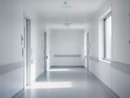 Ein heller, minimalistischer Klinikflur mit weißer Architektur und natürlichem Lichteinfall. - Foto: über boerse-global.de