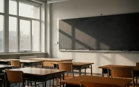 Ein leerer, modern gestalteter Klassenraum mit Holztischen und Stühlen bei natürlichem Tageslichteinfall. - Foto: über boerse-global.de