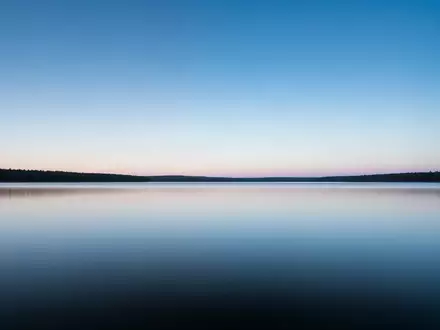 Eine ruhige Seenlandschaft bei Sonnenaufgang, die Klarheit und innere Stärke symbolisiert. - Foto: über boerse-global.de