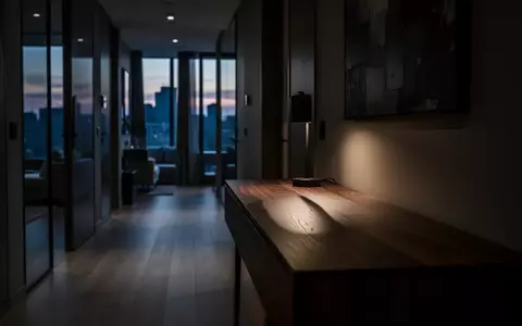 Ein dämmrig beleuchteter Flur mit einem Holztisch, auf den ein langer Schatten fällt. - Foto: über boerse-global.de