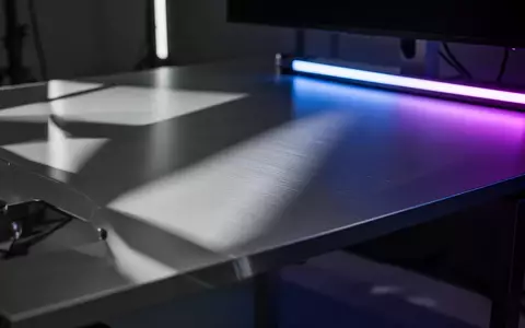 Ein minimalistischer, moderner Arbeitsplatz mit einer gebürsteten Aluminiumoberfläche und subtiler blauer Beleuchtung. - Foto: über boerse-global.de