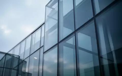 Abstrakte Architekturaufnahme eines modernen Glasgebäudes bei bewölktem Himmel zur Symbolisierung digitaler Sicherheitsrisiken. - Foto: über boerse-global.de