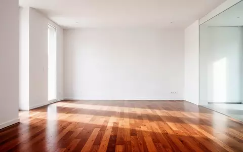 Ein heller, minimalistischer Wohnraum mit poliertem Parkettboden in einer modernen Wohnung. - Foto: über boerse-global.de