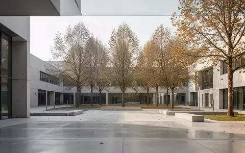 Ein moderner, heller Universitäts-Campus mit klaren architektonischen Linien und Bäumen im Hintergrund bei natürlichem Tageslicht. - Foto: über boerse-global.de