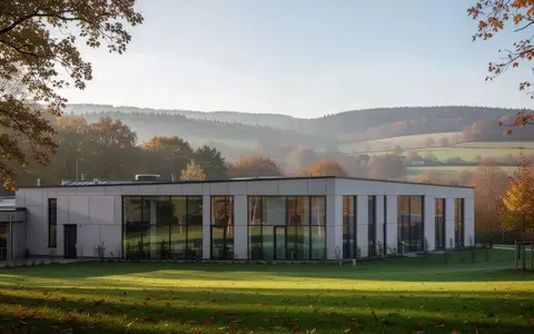 Modernes Klinikgebäude in einer grünen Hügellandschaft in Hessen bei hellem Tageslicht. - Foto: über boerse-global.de