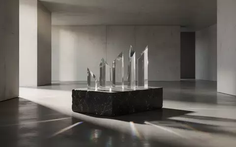 Ein minimalistischer Innenraum mit klaren Linien, poliertem Beton und abstrakten Glasprismen, die sanftes Licht reflektieren. - Foto: über boerse-global.de