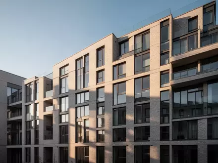 Moderne Fassade eines Wohnhauses bei Tageslicht, die den urbanen Wohnungsmarkt symbolisiert. - Foto: über boerse-global.de