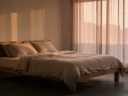 Ein minimalistisch eingerichtetes Schlafzimmer mit sanftem Tageslicht, das Ruhe und Erholung symbolisiert. - Foto: über boerse-global.de
