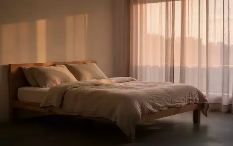 Ein minimalistisch eingerichtetes Schlafzimmer mit sanftem Tageslicht, das Ruhe und Erholung symbolisiert. - Foto: über boerse-global.de