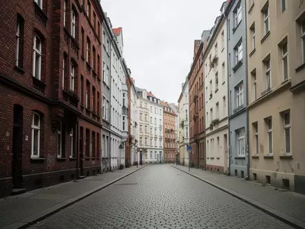 Eine menschenleere Straße in einem Berliner Wohnviertel mit historischer Architektur unter einem grauen Himmel. - Foto: über boerse-global.de