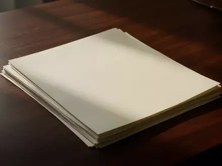 Ein Stapel leerer Dokumente auf einem dunklen Holztisch, die eine bürokratische oder rechtliche Atmosphäre vermitteln. - Foto: über boerse-global.de