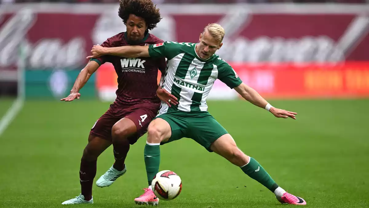 Im Zweikampf: Han-Noah Massengo vom FC Augsburg (l) und der Bremer Marco Grüll. - Bild: David Inderlied/dpa