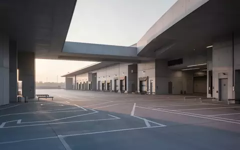Ein minimalistisches, modernes Logistik-Terminal bei Tagesanbruch mit klaren architektonischen Linien und Betonflächen. - Foto: über boerse-global.de