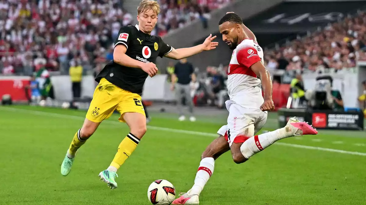 Bloß weg damit: Stuttgarts Josha Vagnoman (r) holt aus, beobachtet von BVB-Spieler Daniel Svensson. - Bild: Jan-Philipp Strobel/dpa