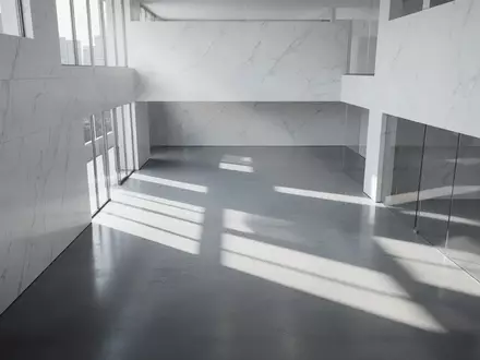 Minimalistische, moderne Architektur mit klaren Linien und hellem Lichteinfall in einem leeren, weitlĂ€ufigen GebĂ€udeinnenraum. - Foto: ĂŒber boerse-global.de