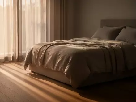 Ein ordentlich gemachtes Bett in einem ruhig beleuchteten Schlafzimmer bei natürlichem Morgenlicht. - Foto: über boerse-global.de
