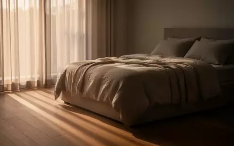Ein ordentlich gemachtes Bett in einem ruhig beleuchteten Schlafzimmer bei natürlichem Morgenlicht. - Foto: über boerse-global.de