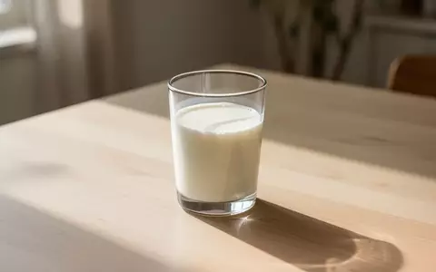 Ein Glas mit frischer Milch auf einem hellen Holztisch in hellem Morgenlicht. - Foto: über boerse-global.de