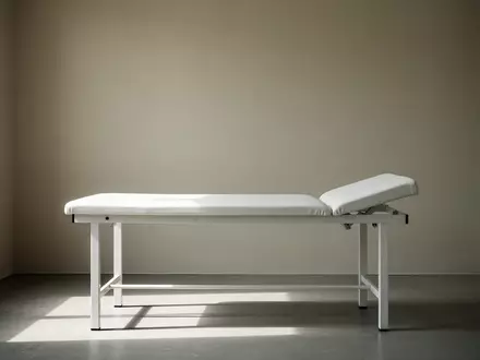 Ein minimalistischer Behandlungsraum mit einem leeren klinischen Untersuchungstisch in hellem, natĂĽrlichem Licht. - Foto: ĂĽber boerse-global.de
