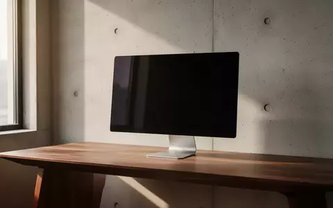 Ein minimalistischer Arbeitsplatz mit einem ausgeschalteten Monitor und natürlichem Lichteinfall in einer modernen Büroumgebung. - Foto: über boerse-global.de