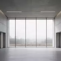 Ein minimalistischer, leerer Flur in einem modernen Verwaltungsgebäude mit großen Fenstern und Blick auf eine Landschaft. - Foto: über boerse-global.de