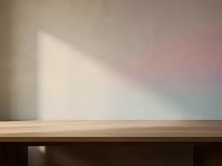 Ein minimalistischer Arbeitsbereich mit sanftem, natürlichem Licht und subtilen Farbverläufen an einer Wand. - Foto: über boerse-global.de