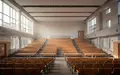 Ein heller, leerer Schulsaal mit moderner Architektur und großen Fensterfronten. - Foto: über boerse-global.de