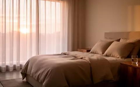 Ein minimalistisch eingerichtetes Schlafzimmer bei Tagesanbruch mit weichem Licht und einer ruhigen, erholsamen Atmosphäre. - Foto: über boerse-global.de