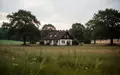 Ein abgelegenes Wohnhaus auf einem weitläufigen Grundstück in einer ländlichen Region unter einem bewölkten Himmel. - Foto: über boerse-global.de