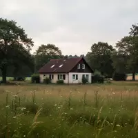 Ein abgelegenes Wohnhaus auf einem weitläufigen Grundstück in einer ländlichen Region unter einem bewölkten Himmel. - Foto: über boerse-global.de