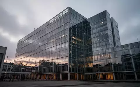 Die Glasfassade des Berlaymont-Gebäudes in Brüssel bei Dämmerung unter einem bewölkten Himmel. - Foto: über boerse-global.de