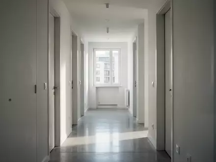 Moderner, heller Flur eines Wohngebäudes mit minimalistischer Architektur und einfallendem Tageslicht. - Foto: über boerse-global.de