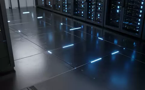 Ein minimalistischer Serverraum mit blau leuchtenden Statusleuchten auf poliertem Metallboden. - Foto: über boerse-global.de