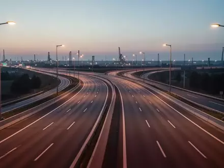 Eine leere, moderne mehrspurige Autobahn bei Dämmerung mit klaren Fahrbahnmarkierungen und Straßenbeleuchtung. - Foto: über boerse-global.de