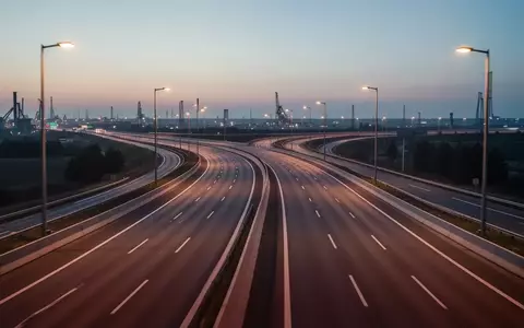 Eine leere, moderne mehrspurige Autobahn bei Dämmerung mit klaren Fahrbahnmarkierungen und Straßenbeleuchtung. - Foto: über boerse-global.de