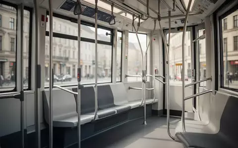 Leerer Innenraum einer modernen Straßenbahn mit Sitzen und Haltestangen in einer urbanen Umgebung. - Foto: über boerse-global.de