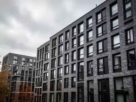 Fassade eines modernen Wohnblocks in Hamburg bei bewölktem Himmel als Symbol für den angespannten Wohnungsmarkt. - Foto: über boerse-global.de