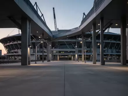 Leerer Betonvorplatz vor einem modernen Fußballstadion in der Abenddämmerung. - Foto: über boerse-global.de