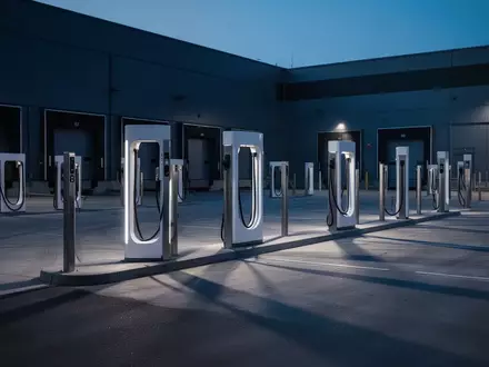 Moderne Ladeinfrastruktur für Elektrofahrzeuge auf einem gewerblichen Betriebshof in der Abenddämmerung. - Foto: über boerse-global.de