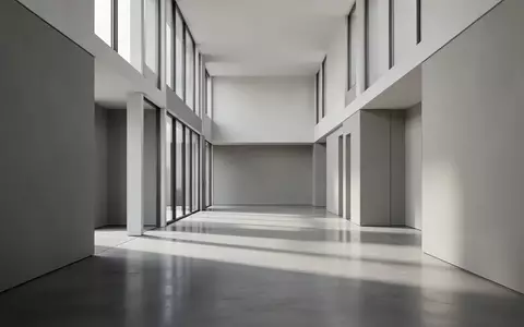 Ein heller, minimalistischer Flur mit poliertem Betonboden und sanftem Tageslicht, das durch hohe Fenster fällt. - Foto: über boerse-global.de