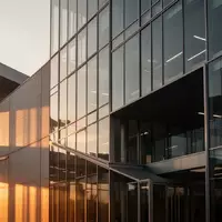 Moderne Glas- und Stahlfassade eines Firmengebäudes im goldenen Licht der Abendsonne. - Foto: über boerse-global.de