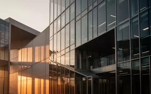 Moderne Glas- und Stahlfassade eines Firmengebäudes im goldenen Licht der Abendsonne. - Foto: über boerse-global.de