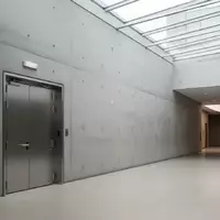 Ein minimalistischer Flur in einem öffentlichen Gebäude mit einer massiven Brandschutztür in einer Betonwand. - Foto: über boerse-global.de